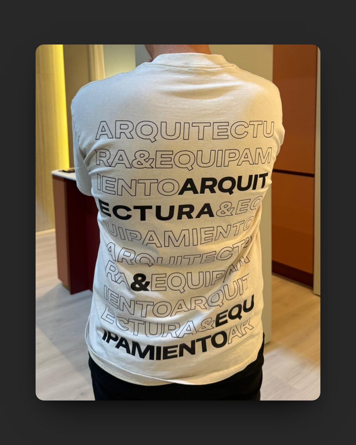 La remera tipográfica puesta, de espaldas, en el stand de la Feria de la Construcción
